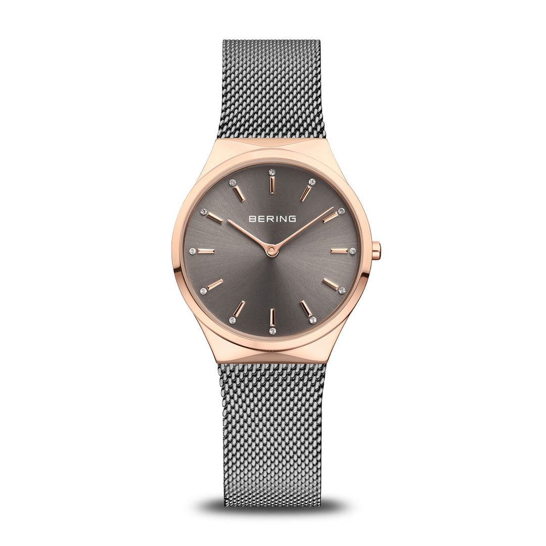Ontdek de elegantie van Berings 12131-369-GWP horloge, met een strakke roestvrijstalen Milanese band en minimalistisch design. De ronde wijzerplaat heeft een quartz uurwerk, grijze wijzerplaat met gouden markeringen en wijzers, omhuld door een slanke roségouden lunette. De merknaam staat gecentreerd op de wijzerplaat.