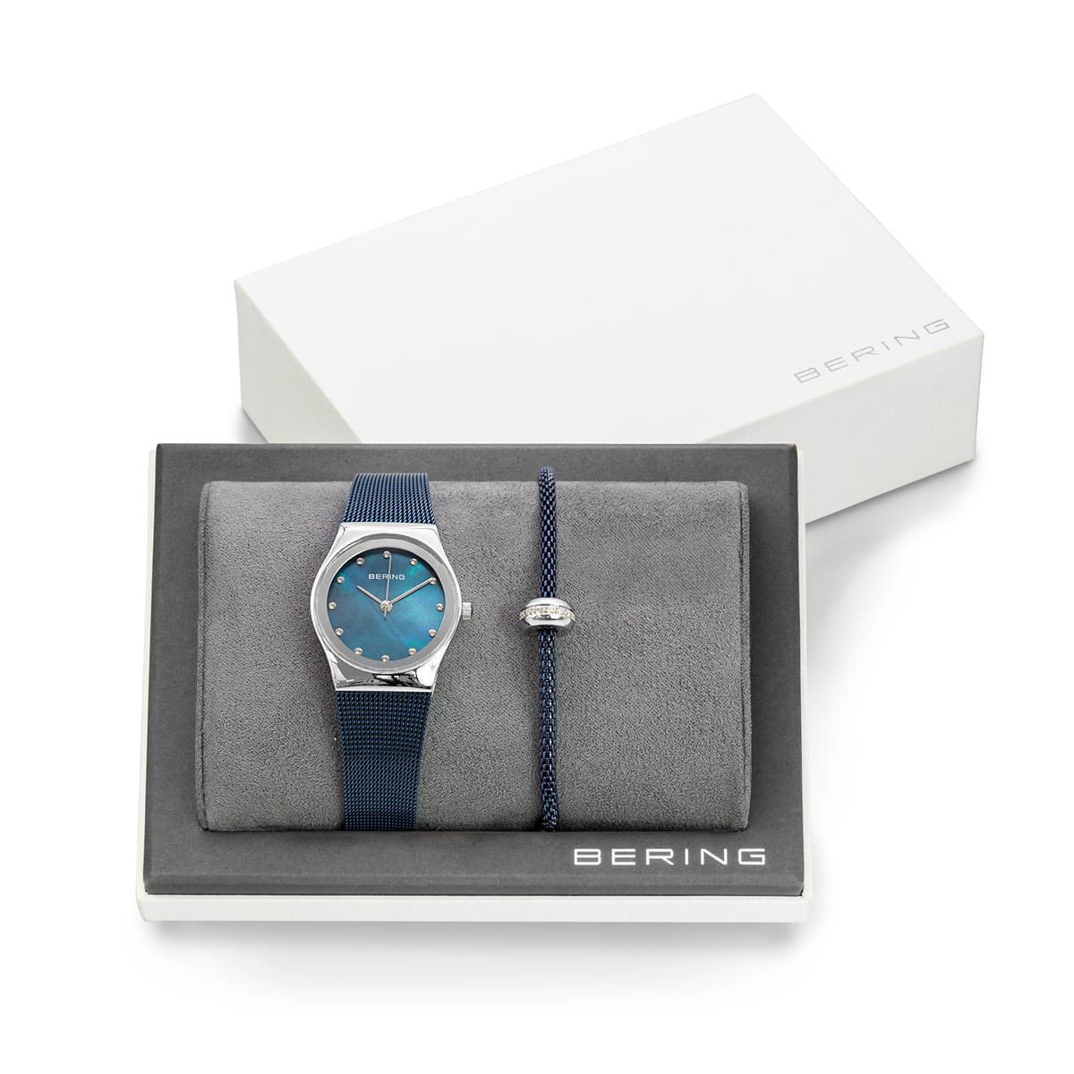 Orologio con quadrante blu e cinturino in silicone, accompagnato da bracciale in corda con dettaglio argentato.