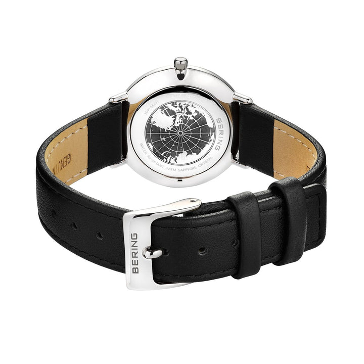De afbeelding toont de achterkant van het Bering 15729-404 dameshorloge, met een zilveren kast, zwarte leren band en quartz-uurwerk. De achterkant is gedetailleerd gegraveerd met een wereldkaart en specificaties, allemaal beschermd door duurzaam saffierglas.
