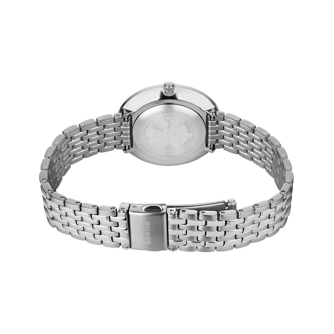 Het Bering Damen horloge 19334-004, met een minimalistisch design en een metalen schakelband, wordt met de voorkant naar beneden getoond, met een ronde achterkant en een sluiting met de gravure Bering op een effen witte achtergrond.
