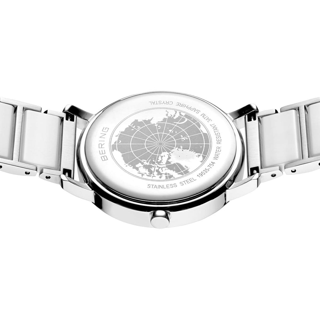 Het elegante Bering dameshorloge 19535-754 heeft een zilveren achterkant met een gegraveerde kaart en opschriften BERING, Stainless Steel, 316L, Sapphire Crystal, genummerd 15531-754, voorzien van een zilverkleurige keramische band en geavanceerde zonnetechnologie voor stijlvolle efficiëntie.
