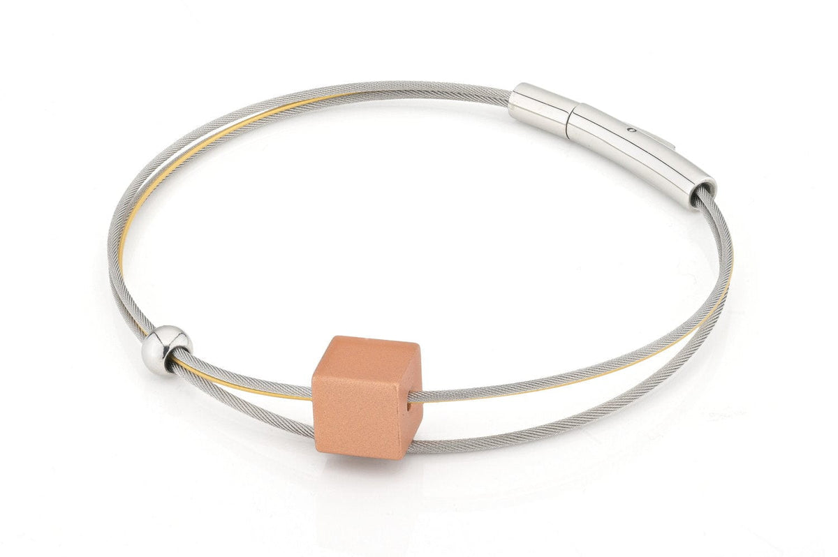 Bracciale in acciaio inox con un elemento cubico rosa e dettagli argentati.