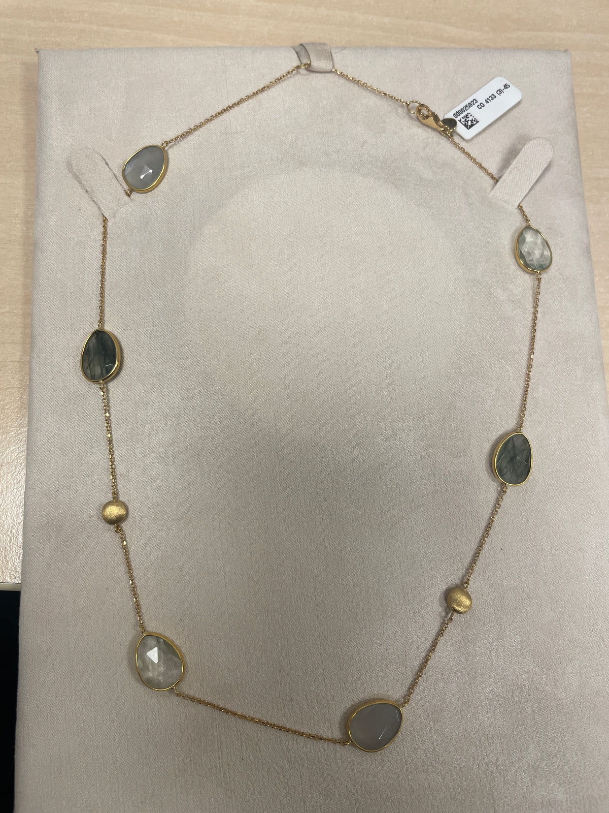 Collana con pietre ovali e dettagli dorati.
