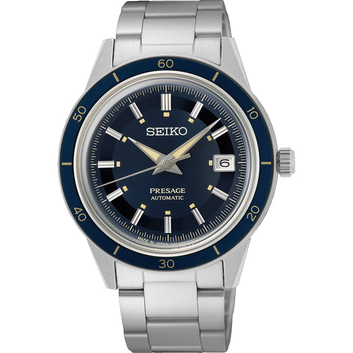 De Seiko Prospex SRPG05J1 is een prachtig herenhorloge met een zilveren band, een donkerblauwe wijzerplaat met lichtgevende wijzers en een datumweergave op 3 uur, samen met een blauwe lunette met minutenmarkeringen, alles gevat in roestvrij staal.