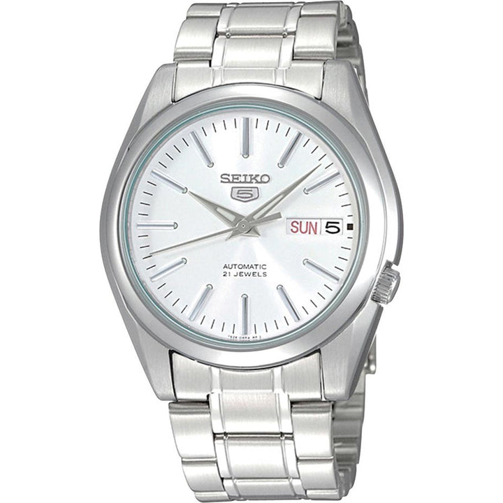Het Seiko herenhorloge SNKL41K1 heeft een zilveren roestvrijstalen band en kast, een witte wijzerplaat met zilveren markeringen, wijzers en een dag-datumvenster voor zondag 5. Het heeft een automatisch mechanisme met Hardlex mineraal glasbescherming en is gelabeld Automatic 21 Jewels.