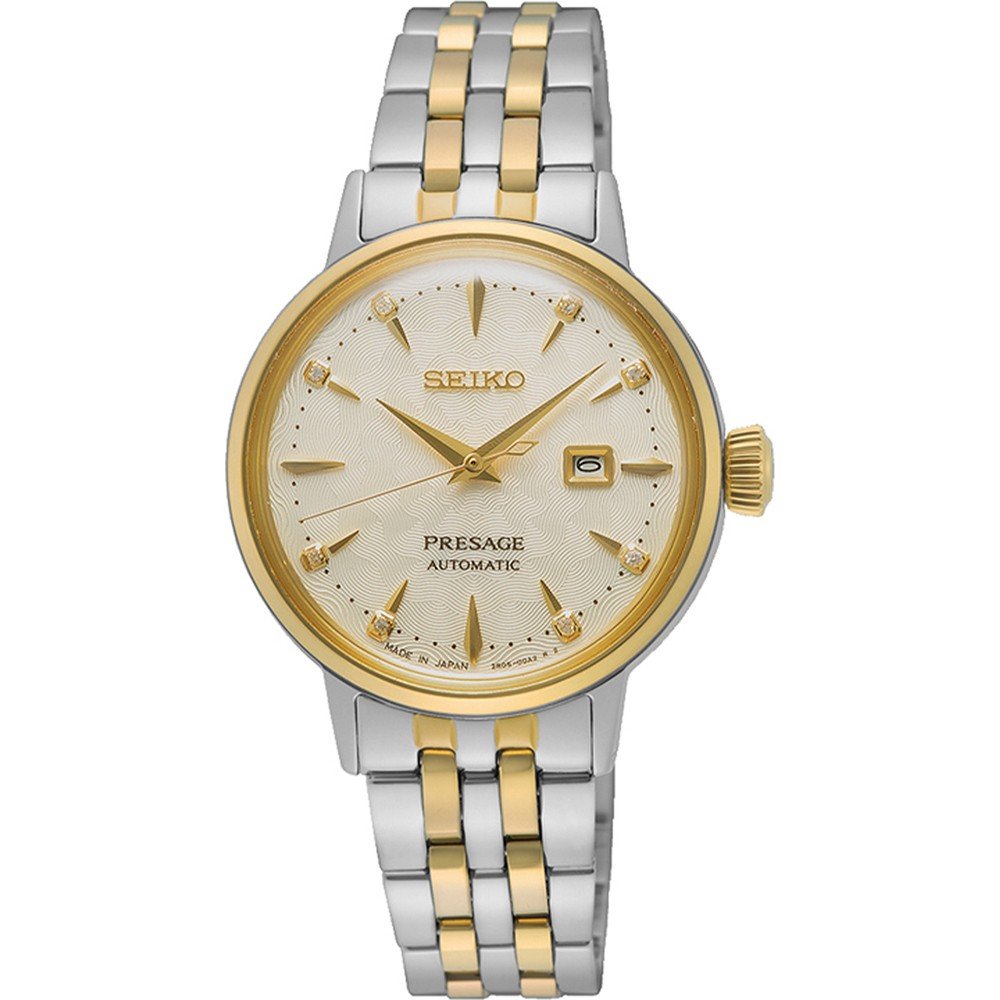 De Seiko Presage dames horloge SRE010J1 van Seiko heeft een automatisch uurwerk, goud-zilveren metalen band, gouden bezel, crèmekleurige wijzerplaat, gouden uurmarkeringen, datumvenster op 3 uur en drie gouden wijzers.