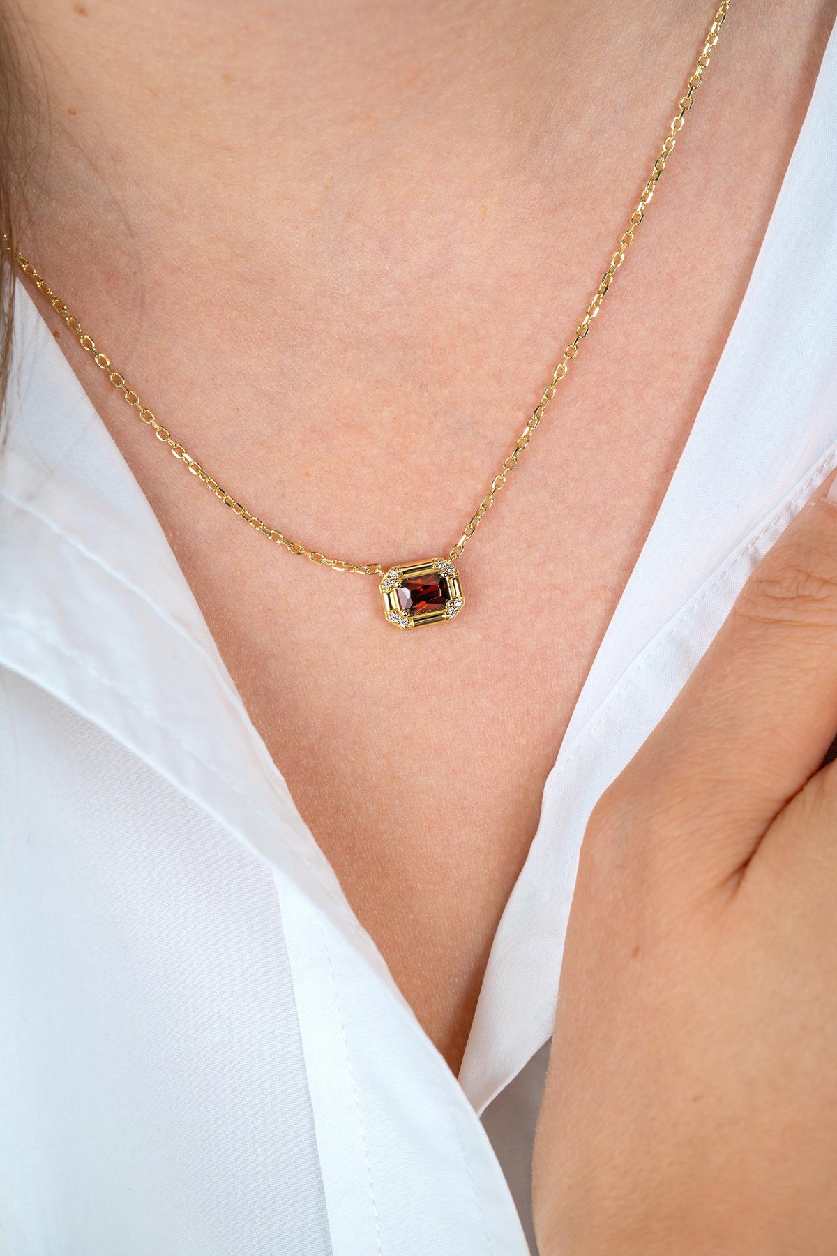 Gouden vergulde zilveren ketting van 45 cm met een vierkant, rood steentje in een omlijsting.
