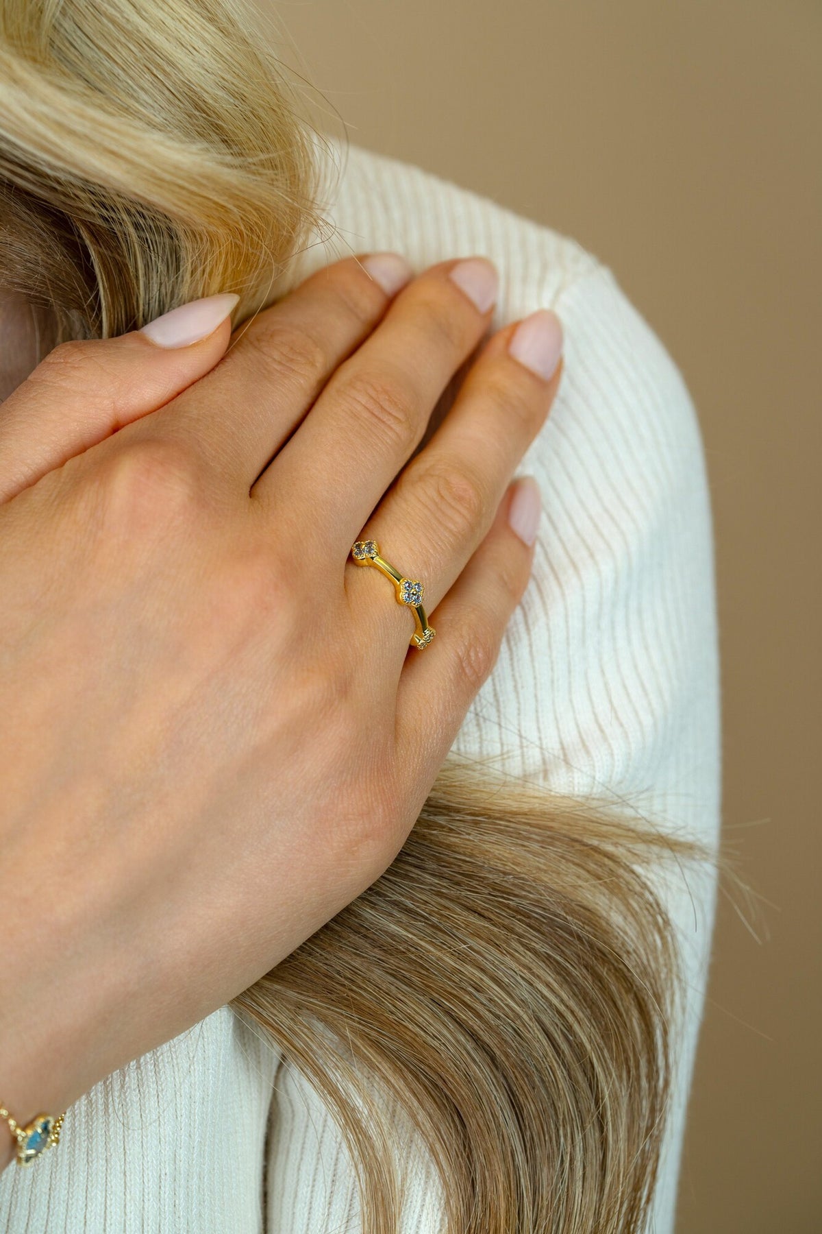 Anello dorato con dettagli in zirconia, design sinuoso e delicato.