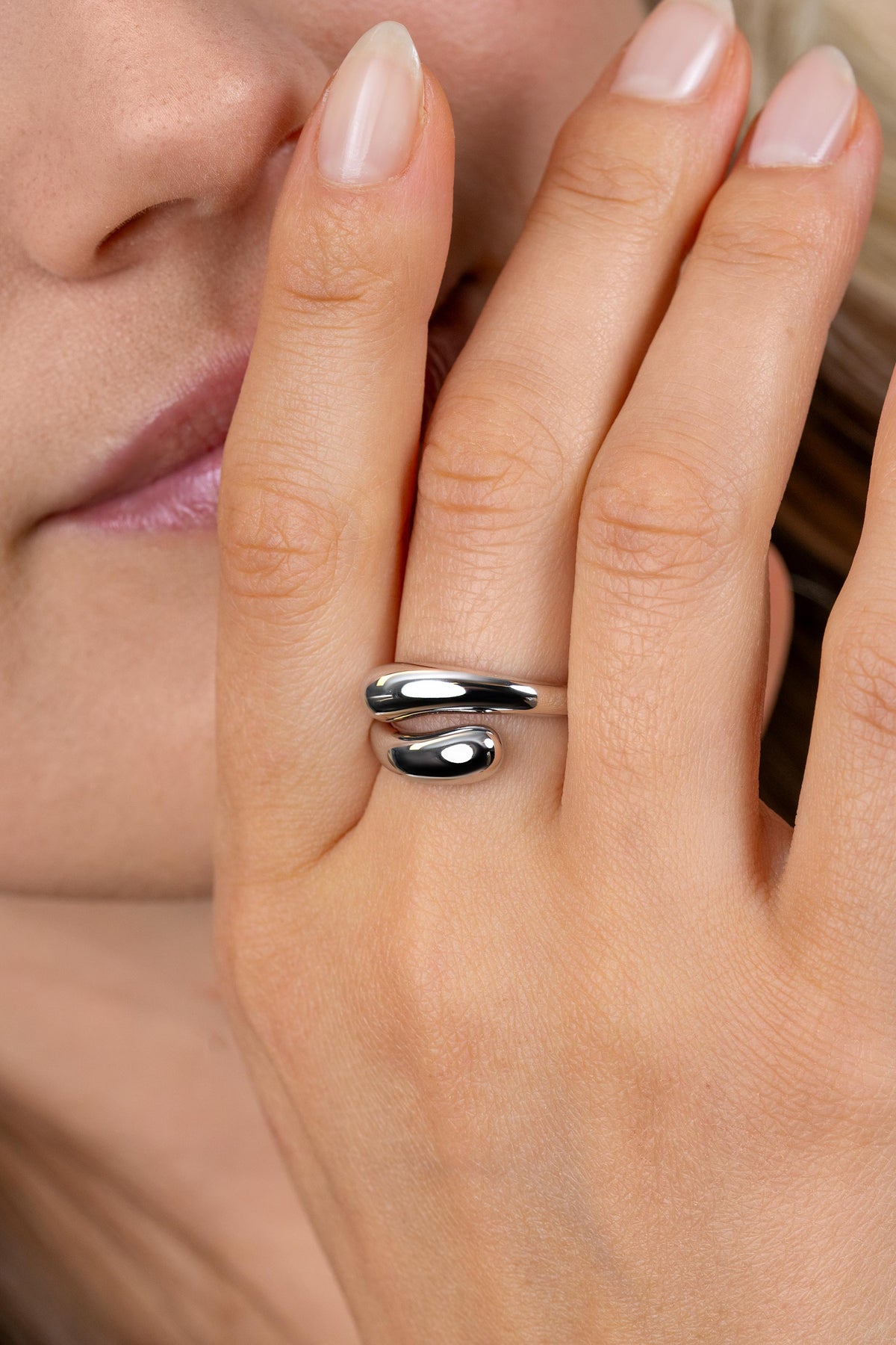 Anello in argento con forma organica, caratterizzato da due elementi sovrapposti e lucidi.