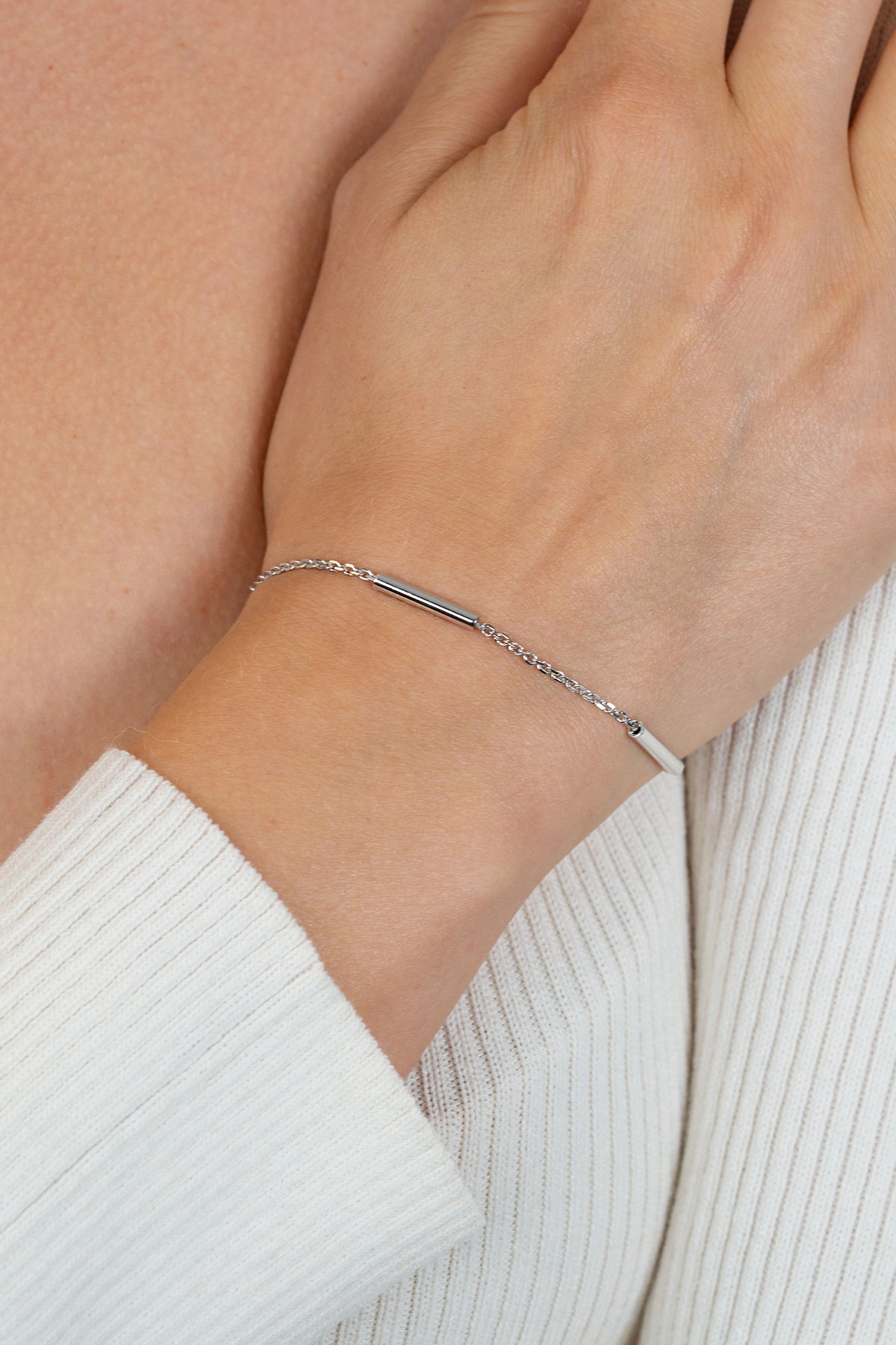 Bracciale in argento con tre barre cilindriche lisce e catena fine.