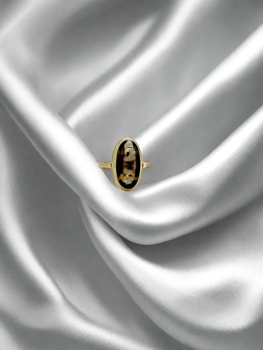 Anello vintage in oro 14k con quarzo fumé, forma ovale e dettagli decorativi.