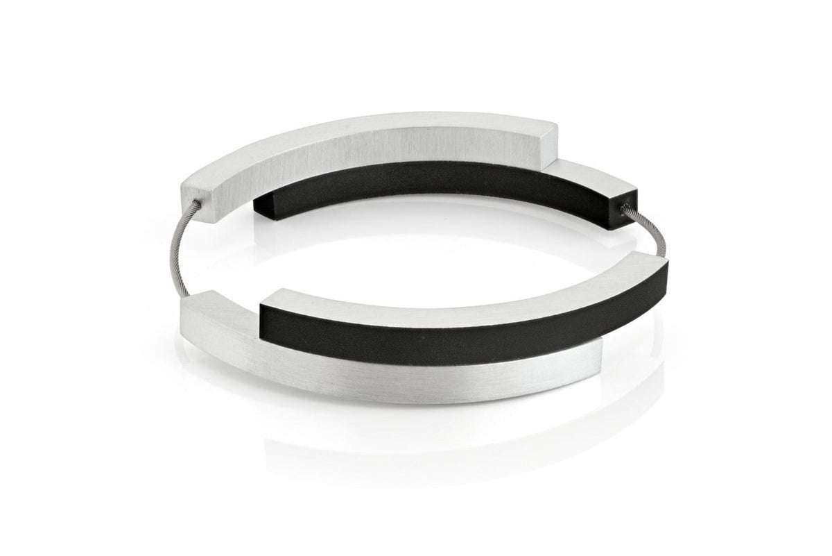 Bracciale con quattro archi in metallo argentato e dettagli neri.