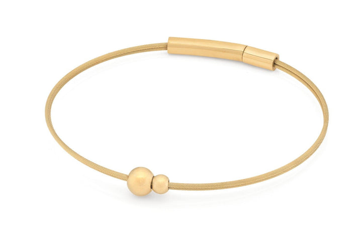De Thinking of You Armband A710GG van CLIC Creations is een dunne, goudkleurige armband met een gladde ronde kraal en een iets grotere kraal, afgewerkt met een strakke bajonetsluiting voor een elegante minimalistische look.