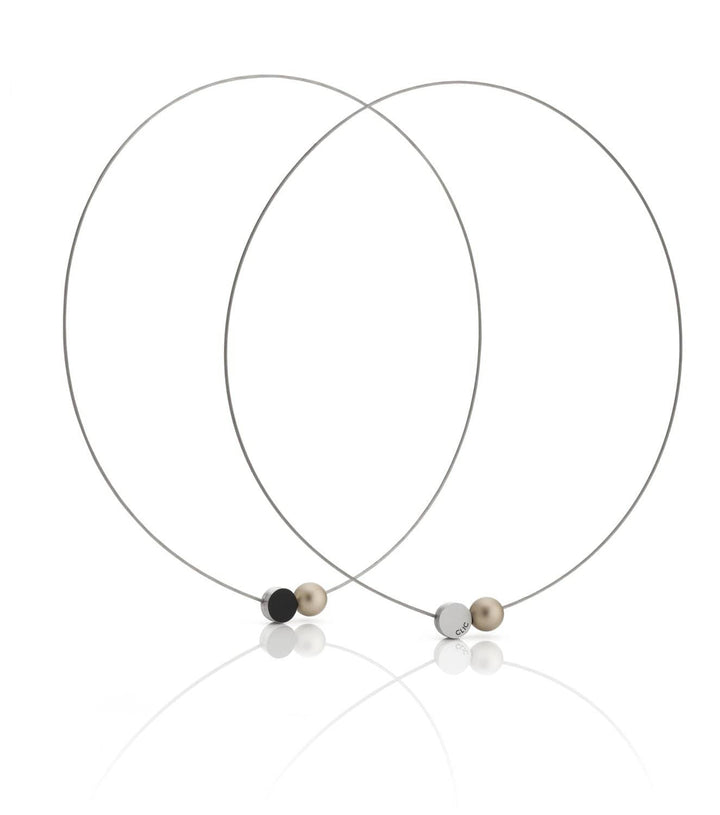 De Collier Mini Kogeltje Goud C192G van CLIC Creations bestaat uit twee dunne kettingen met kleine bolvormige kralen in zwart, beige en zilver en een magnetische sluiting. Ze zijn handgemaakt in Nederland en overlappen elegant met kralen die aan de voorkant op een reflecterend oppervlak zijn geplaatst.