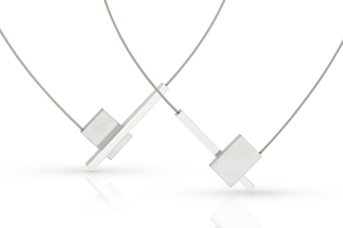 De Collier V-vorm met staafje C261 van CLIC Creations heeft een minimalistisch design met een geometrische rechthoekige hanger aan een dunne ketting en een makkelijke magnetische sluiting, afgebeeld op een witte achtergrond. Dit unieke stuk is handgemaakt in Nederland.