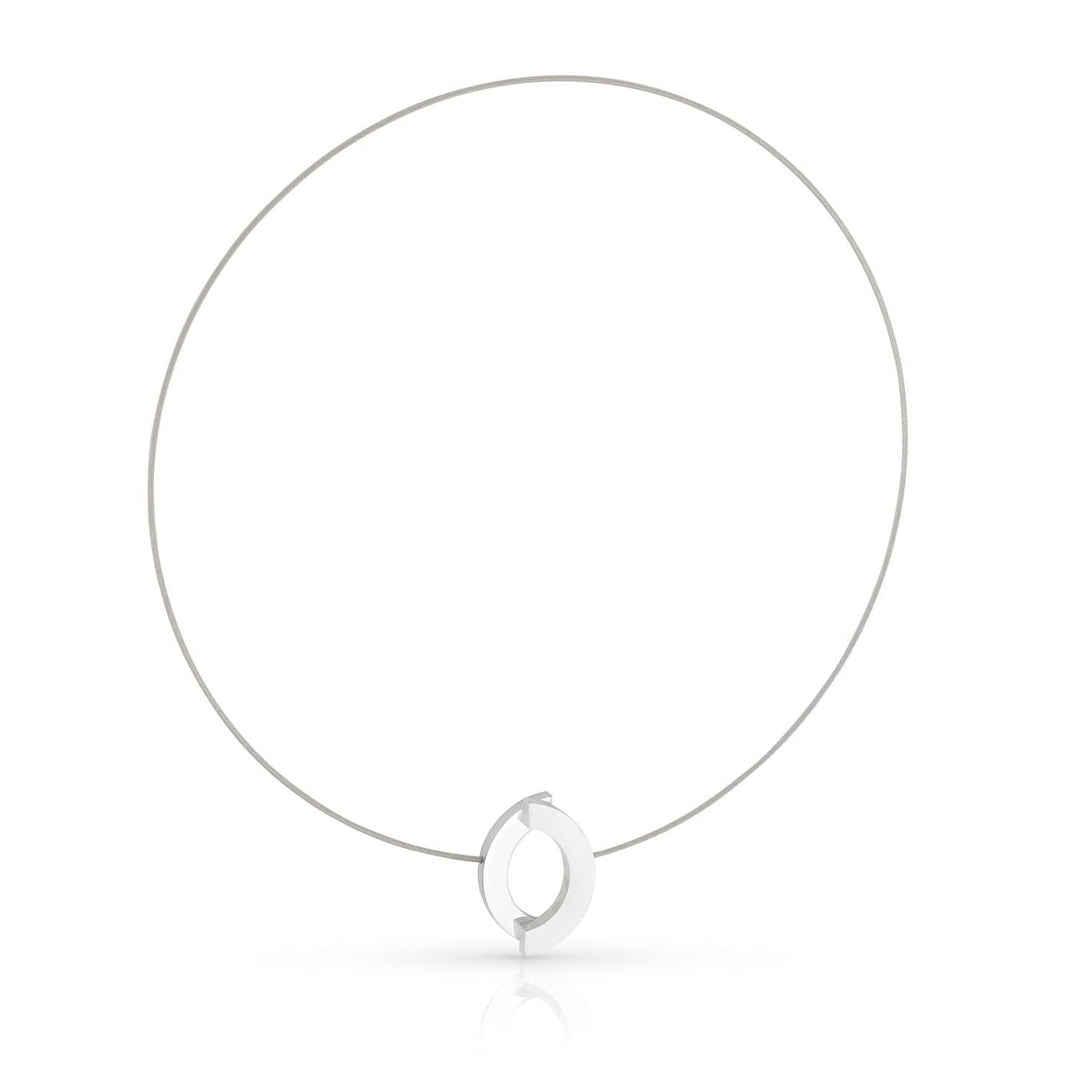 De Collier Boogjes C262 van CLIC Creations is een minimalistische zilveren ketting met een strak design, bestaande uit een dunne draad en een open cirkelvormige hanger met een klein verticaal staafje. De ketting is handgemaakt in Nederland en heeft een effen witte achtergrond voor een moderne look.
