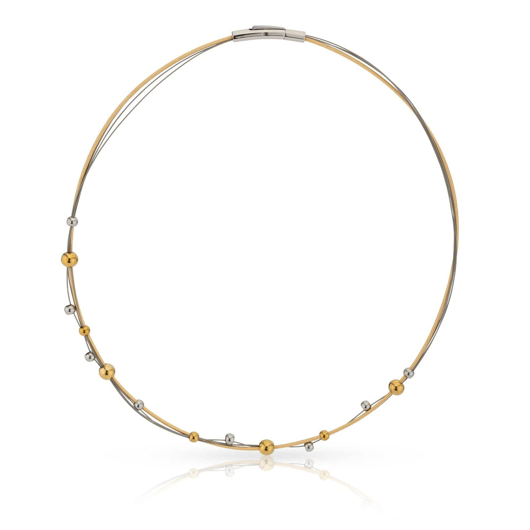 Het Collier speelse bolletjes bicolor C269BI van CLIC Creations heeft twee dunne lussen met gelijkmatig verdeelde gouden en zilveren kralen op delicate strengen van chirurgisch edelstaal, afgewerkt met een strakke bajonetsluiting.