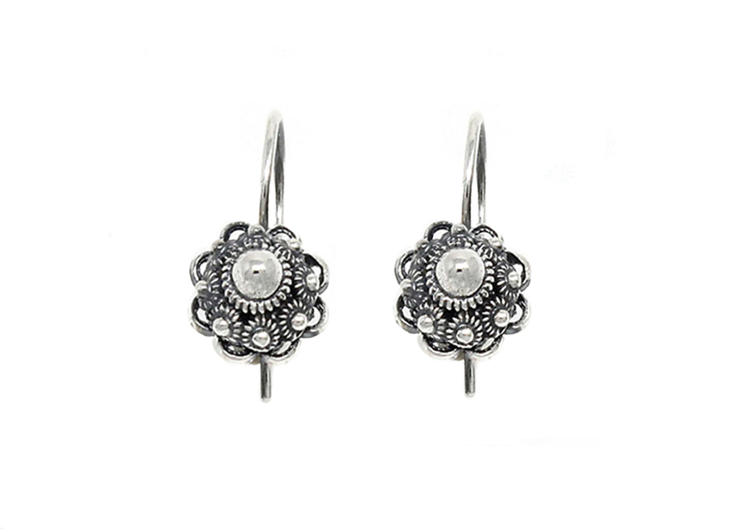 Twee zilveren Zeeuwse Knoop Oorhangers 14mm van Dutch Button met ingewikkelde bloemmotieven en een centrale parel omringd door gedetailleerd kralenwerk, met haakjes om te dragen. De achtergrond is effen wit.