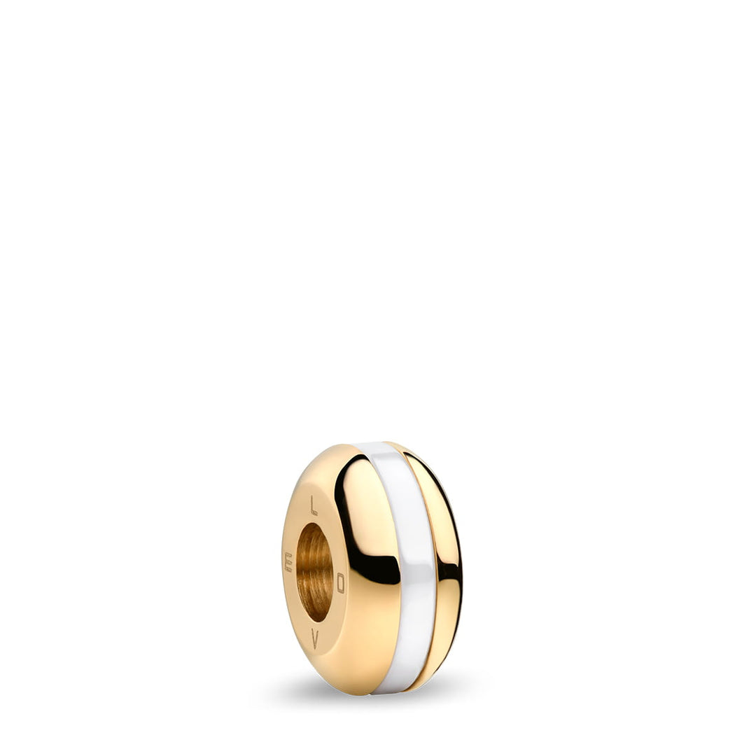 De 11022-334-Lovely-1-GWP190 van Bering is een goud-witte ronde bedel met een centrale witte streep, glad gegraveerd oppervlak zoals Saffierglas, dat het licht prachtig reflecteert. Het staat elegant alleen tegen een ongerepte witte achtergrond die doet denken aan een Bering Dameshorloge.