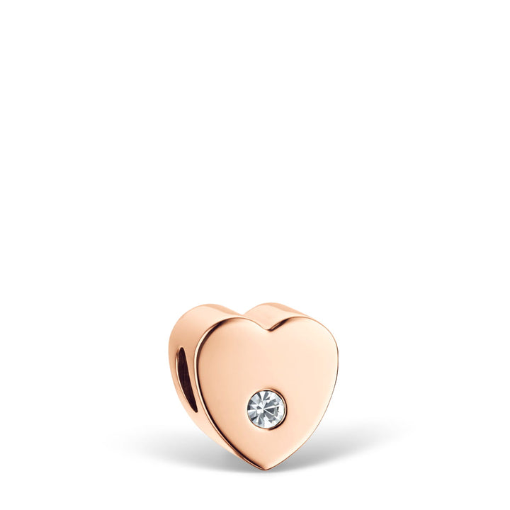 De Bering 12131-339-GWP bedel heeft een hartvormig roségouden ontwerp met een centrale ronde heldere edelsteen, die tijdloze elegantie uitstraalt die vergelijkbaar is met een Bering Dameshorloge. De minimalistische stijl past moeiteloos bij elke Milanees-band, afgebeeld tegen een witte achtergrond.