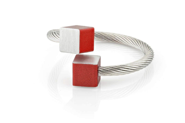 De Ring Kubusjes Rood R4R van CLIC Creations is een handgemaakte armband gemaakt in Nederland van chirurgisch edelstaal. Het heeft een zilveren twist design met rode en zilveren matte kubus uiteinden en reflecteert licht prachtig op witte oppervlakken. One size fits most.