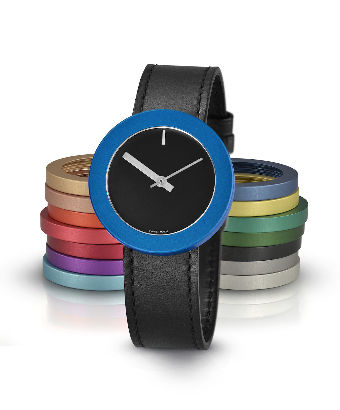 Orologio con quadrante nero, cassa blu e cinturino in pelle nera, con anelli colorati sullo sfondo.