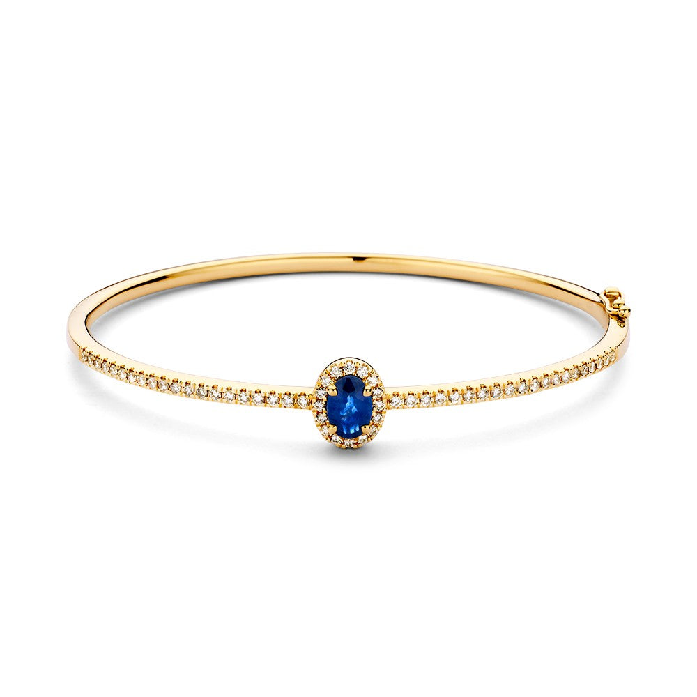 Bracciale in oro 14 carati con diamanti e zaffiro, decorato con un zaffiro ovale circondato da diamanti.