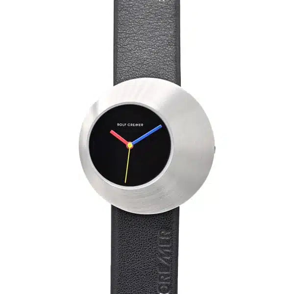 Orologio Rolf Cremer con cassa in acciaio inox e quadrante nero, cinturino in pelle nera, lancette colorate.