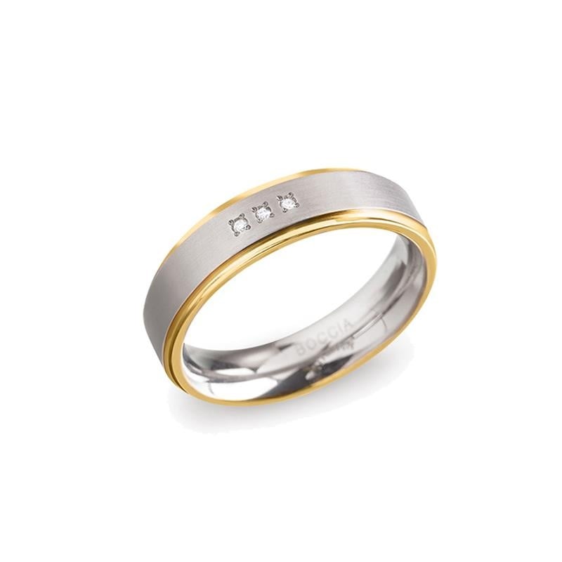 Anello in titanio bicolore con dettagli in oro e tre diamanti.