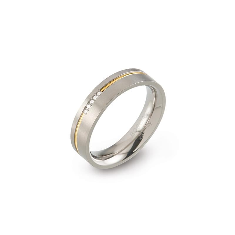 Anello in titanio bicolore con una linea dorata e tre piccoli diamanti.
