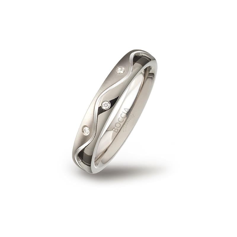 Anello in titanio con design ondulato e tre piccole pietre brillanti.