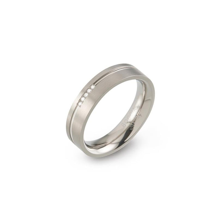 De Boccia Titanium Ring (0149-02) heeft een matte zilveren afwerking met een strakke groef en een rij kleine ingebedde diamanten. Het geheel vormt een elegant en modern design tegen een effen achtergrond.