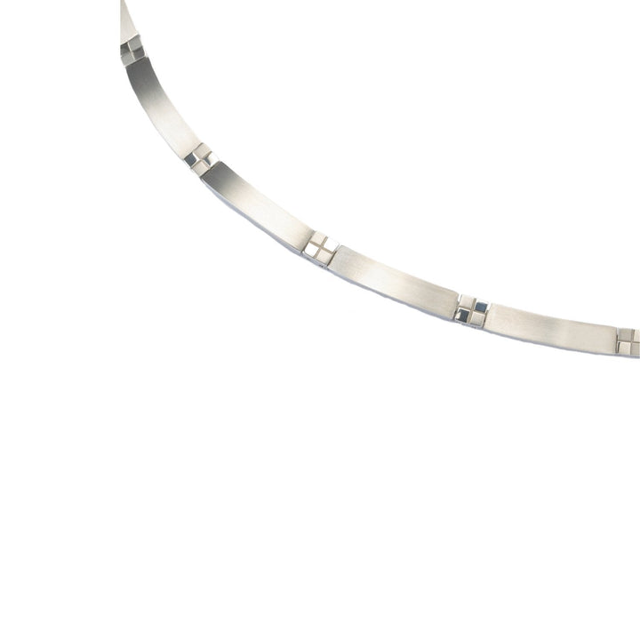 Een close-up van de Boccia Titanium Collier 0831-01, een zilverkleurige ketting van Boccia met rechthoekige, licht gebogen schakels die met vierkante connectoren met elkaar verbonden zijn, gemaakt van duurzame materialen en geplaatst op een effen witte achtergrond.