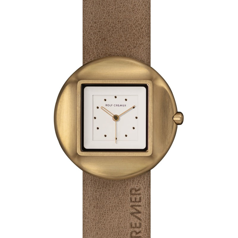 Orologio Rolf Cremer con cassa rotonda in oro e quadrante quadrato bianco, cinturino in pelle beige.