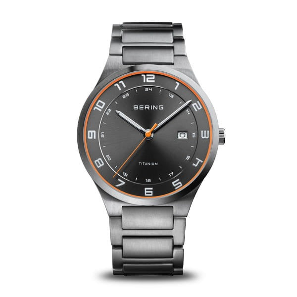 Orologio Bering in titanio con quadrante grigio e dettagli arancioni, cinturino in acciaio.