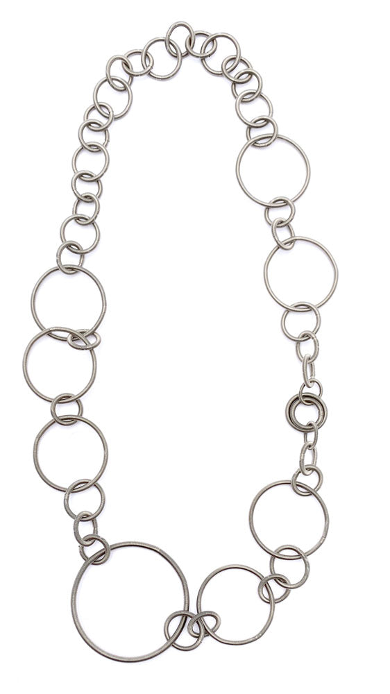 Collana in acciaio con design a cerchi intrecciati di diverse dimensioni.