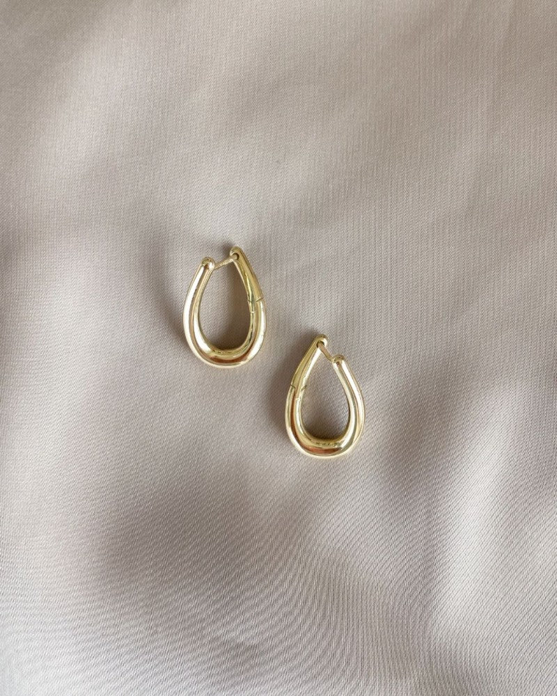Orecchini a cerchio giocosi in oro giallo con twist – Eleganza in movimento
