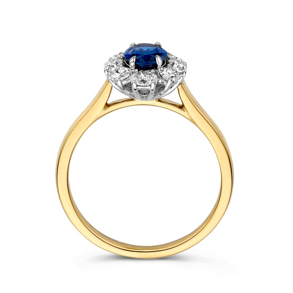 Een Ring bicolor briljant + saffier van Excellent Jewelry, Lady Di stijl: centrale blauwe saffier omringd door fonkelende diamanten in een elegante witgouden zetting.