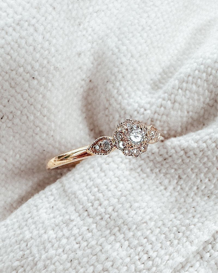 De Verfijnde Geelgouden Ring met Briljant Geslepen Middensteen 0.21 crt. van Excellent Jewelry is een elegante 14 karaat geelgouden ring met een ronde centrale diamant, gefotografeerd op crèmekleurige stof.