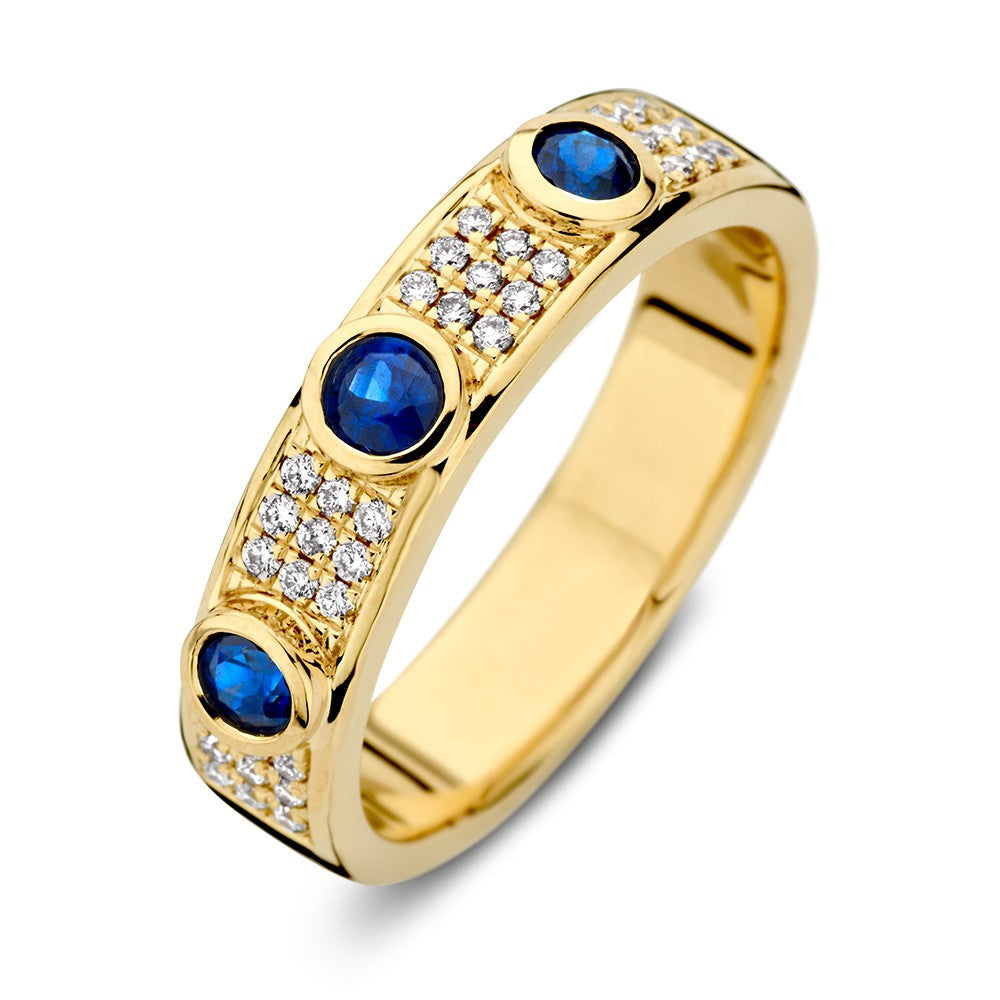 Anello in oro giallo con diamante e tre zaffiri blu, decorato con pietre preziose.