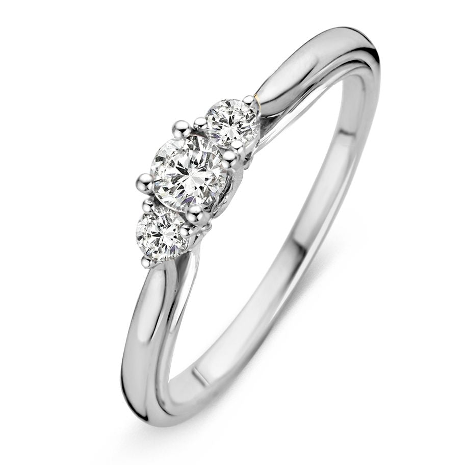 Anello in oro bianco con tre brillanti, il centrale da 0,31 crt, design elegante.