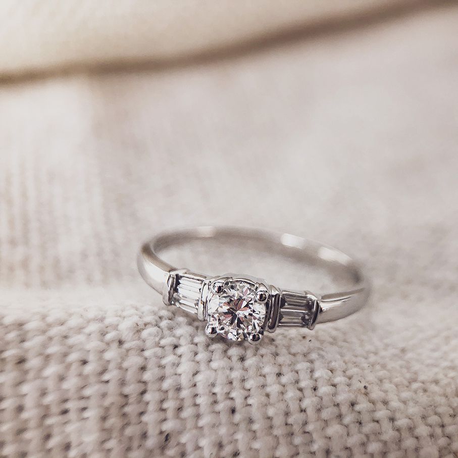 Elegante Anello in Oro Bianco con Pietra Centrale Taglio Brillante e Pietre Laterali Baguette
