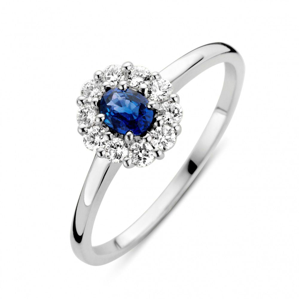 Anello in oro bianco con zaffiro blu e diamanti, design delicato e brillante.
