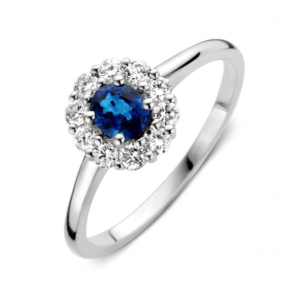 Anello in oro bianco con zaffiro blu al centro e diamanti che lo circondano.