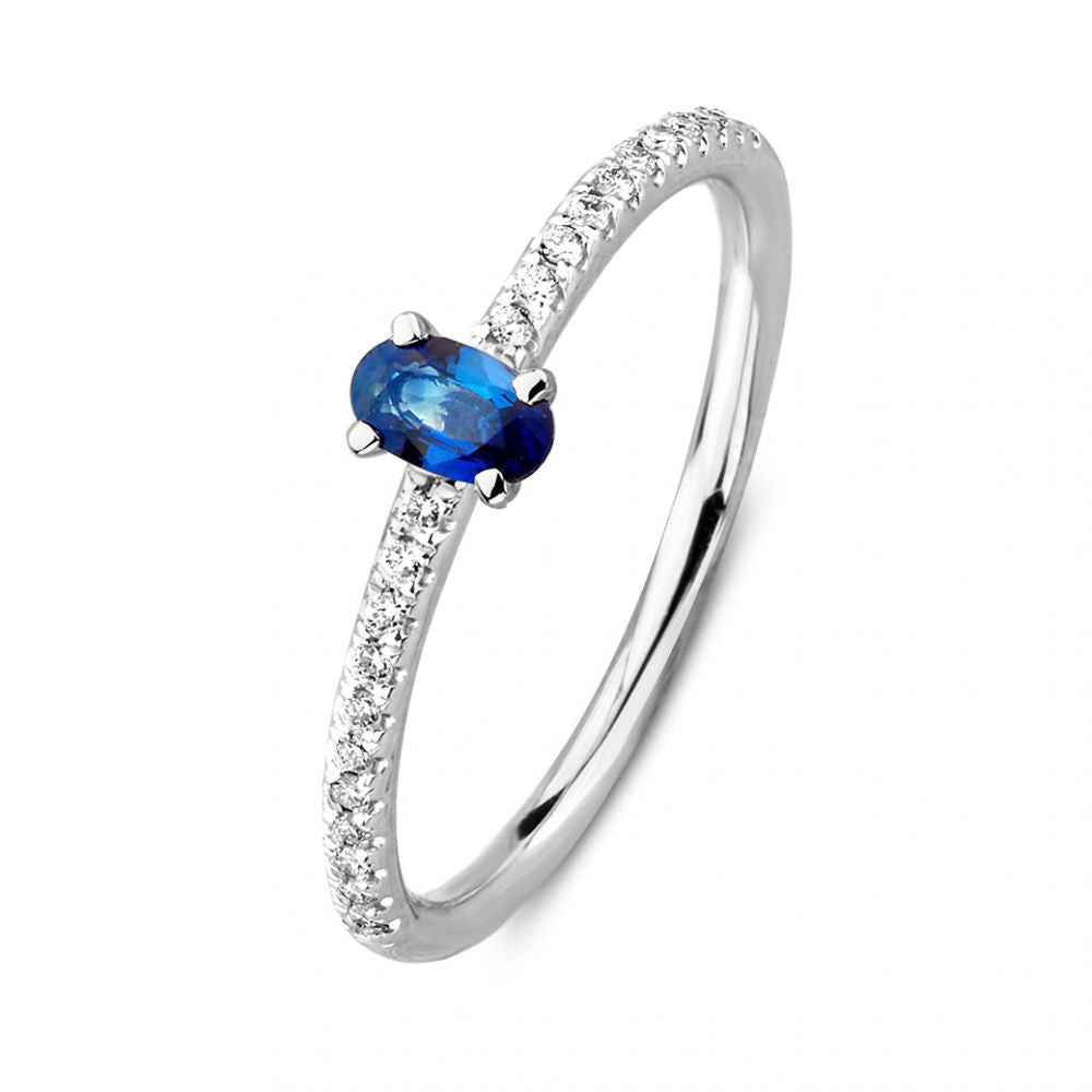 Anello in oro bianco con zaffiro ovale e diamanti lungo la fascia.