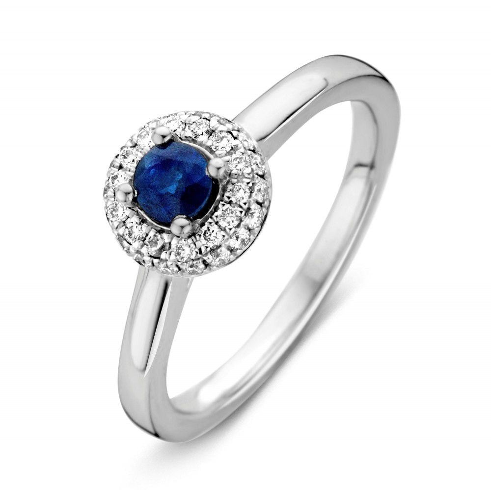 Anello da donna in oro bianco con zaffiro centrale e diamanti, design elegante e rotondo.