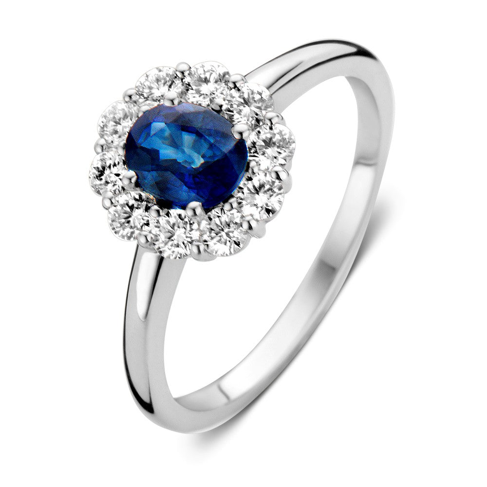 Anello in oro bianco con zaffiro blu al centro, circondato da diamanti.