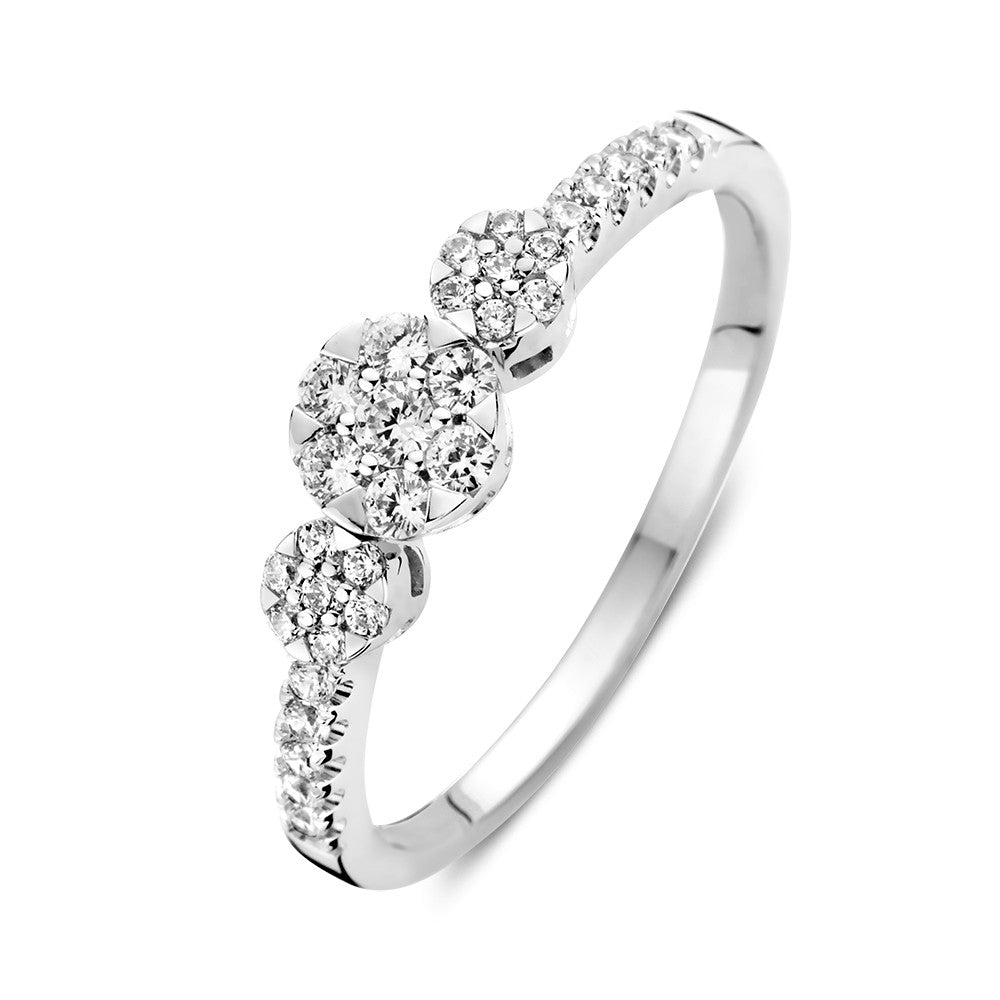 Anello in oro bianco con tre pietre di zirconia e dettagli laterali scintillanti.