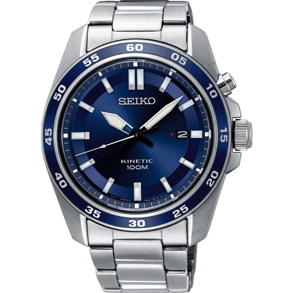 Het Seiko heren horloge SKA783P1 heeft een kinetisch uurwerk, 100M waterdichtheid, roestvrijstalen kast en band, blauwe wijzerplaat met zilverkleurige uurmarkeringen, datum op 3 uur, minutenmarkeringen op de lunette en zilverkleurige wijzers met witte accenten.