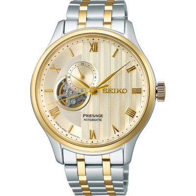Orologio da uomo Seiko Presage con cassa argentata e dorata, quadrante dorato con dettagli a rilievo e indicazioni romane.